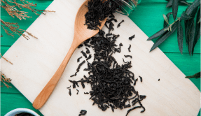 top view dry black tea leaves scattered from glass jar with wooden spoon kitchen cutting board green wood 1 WooCommerce Plugin Development