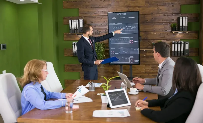 businessman suit having presentation with charts tv screen conference rom team meeting 1 e1780997741676